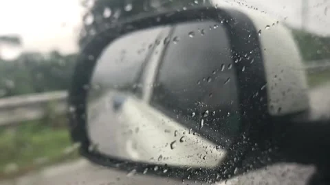 Video of view from side mirror while car is driving on rural road in the rain Stock Footage 285586408