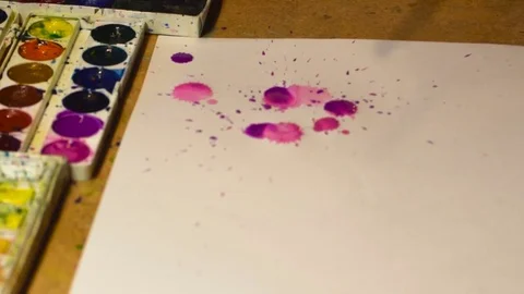 Video of watercolor drops on a white sheet of paper. Stock Footage