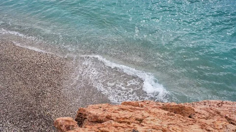 Video of the waves rolling on a pebble beach. Beautiful sea coast  Stock Footage 127931787