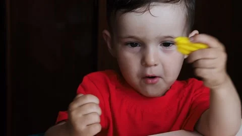 A video in which a small child boy holds a colored plasticine in his hands. Stock Footage 169584291