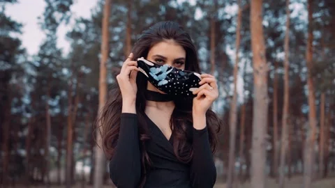 A video in which a young lady puts her mask on her face. Video stock 131769026