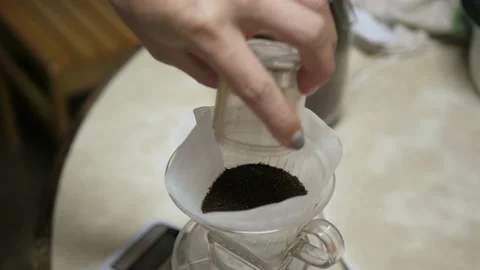 Video while putting fresh grinded coffee bean into the filter paper on coffee Stock Footage 220001557