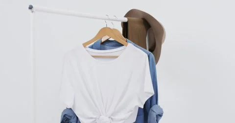 Video of white and denim t shirt on hangers, hat and copy space on white Vídeo Stock 331307273