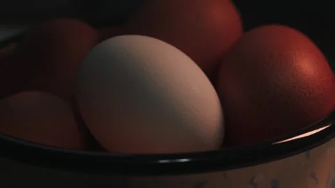 Video of a white egg surrounded by brown eggs in a bowl. Food concept. Stock Footage 262805178