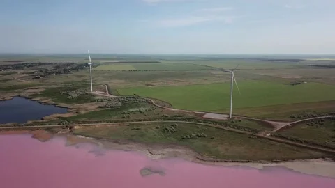 Video of windmills generating electricity and power next to pink salt lake. Stock Footage 208309165