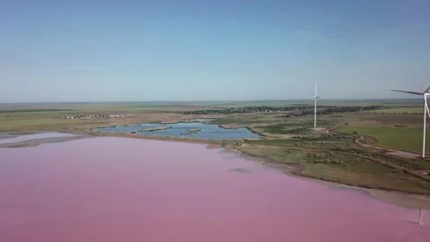 Video of windmills generating electricity and power next to pink salt lake. Vidéo 208312134