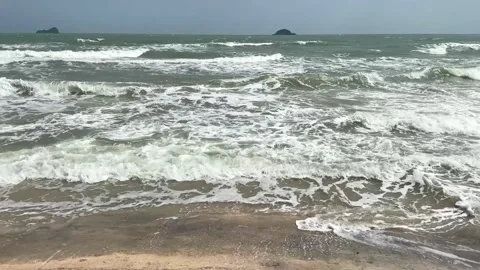 Video of windy ocean waves pushing foamy water onto sandy beach Stock Footage 325417635