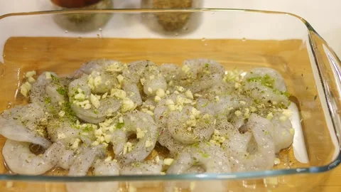 In this video, a woman's hand generously sprinkles fresh shrimp with aromatic Video stock 270342322
