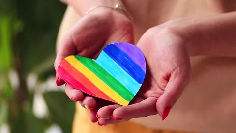Video of woman's hands holding a hand drawn LGBTQ+ heart. Stock Footage 262598582