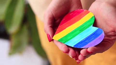 Video of woman's hands holding a hand drawn LGBTQ+ heart. Stock Footage 262598598