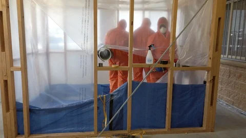 Video of workmen working within an asbestos enclosure preparing for Stock Footage 126497672