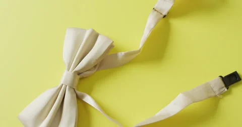Video of yellow bow tie lying on yellow background Stock Footage 336844157