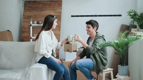 Video of young beautiful couple drinking a cup of coffe while relaxing from m Video stock 221472485