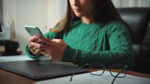 Video of a young Hispanic woman using her smartphone in the office during a work Stock Footage 346329892