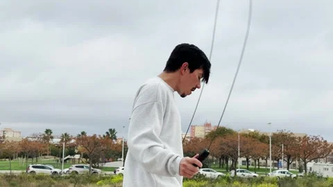 Video of a young man jumping rope outdoors on a cloudy day Video stock 305155916