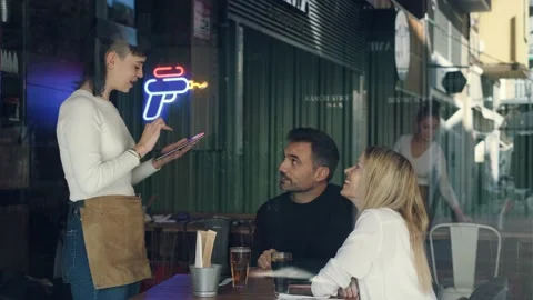 Video of young waitress using application on digital tablet computer to order Stock Footage 219605812