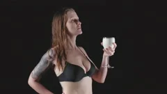 Mad woman drinking water from bottle and pours water on her breasts .  Cropped shot of thirsty