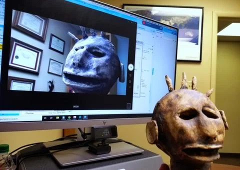 Videoconference telecast with clay talking head on monitor Stock Photos