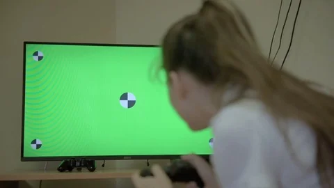 Videogame addicted girl playing with controller console. Green screen tv Young Stock Footage 79403187