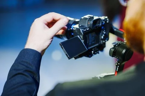 Videographer adjusting camera settings on gimbal 스톡 사진
