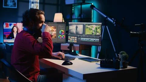 Videographer adjusting clips while enjoying cup of coffee in office Fotos Stock