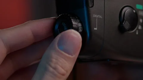 Videographer adjusting digital camera focus dial with icons, selecting modes and Stock Footage 342760945