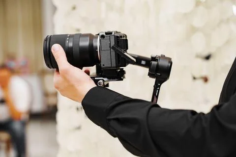 Videographer Adjusting Lens Ring on Camera Gimbal Rig Foto stock