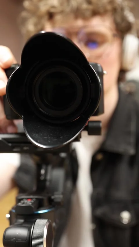 Videographer aiming camera lens toward viewer Stock Footage 332116759