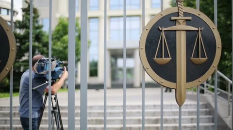 Videographer back behind iron gates of court Stock Footage 42753197