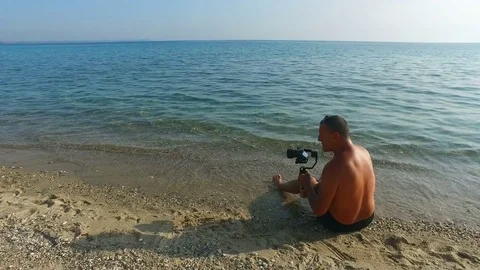 Videographer on the beach with a gimbal Stock Footage 83217992