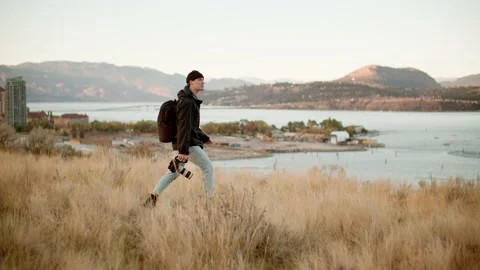 Videographer carrying cinema camera during sunrise, wide 库存影片 209351663