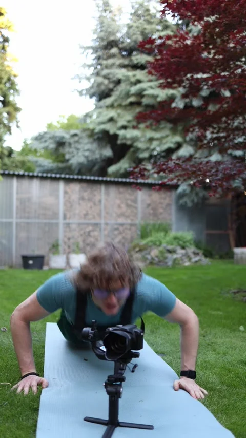Videographer does push ups during filming training Stock Footage 336369138