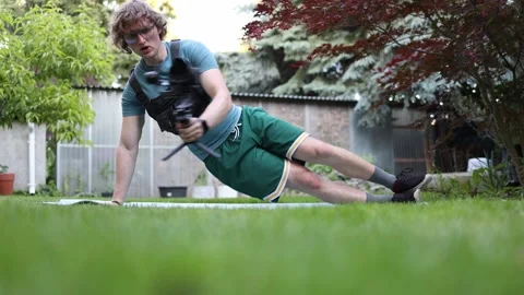 Videographer doing side plank training Stock Footage 336791108