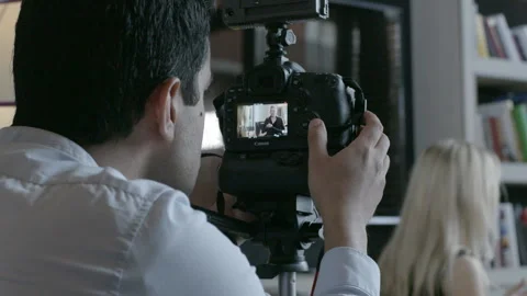 Videographer Filming an Interview on DSLR Camera Stock Footage 343968573