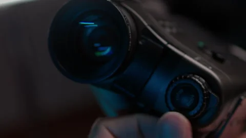 Videographer hands holding old camcorder, adjusting focus dial and zooming lens Stock Footage 342764270