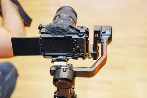 Videographer Holding Camera with Screen Tilted for Low Angle Stock Photos