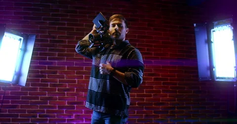 A videographer man professional camera on his shoulder, video lights on the set. Stock Footage 152041440