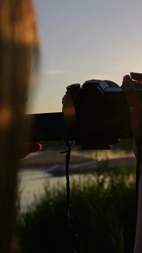 Videographer Operating Mirrorless Camera During Golden Hour Sunset Stock Footage 345422309