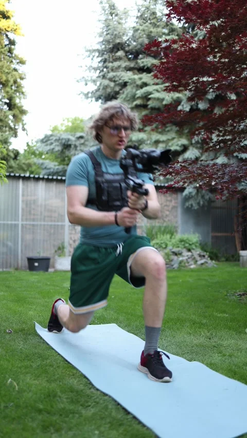 Videographer practicing tracking shots in lunge Stock Footage 336369937