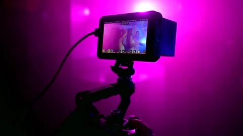 Videographer recording romantic couple dancing at wedding reception Stockbeeldmateriaal 309853297