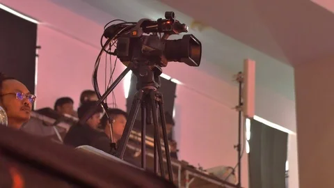 Videographer set up a professional camcorder to record video at a live event Stock Footage 113132725