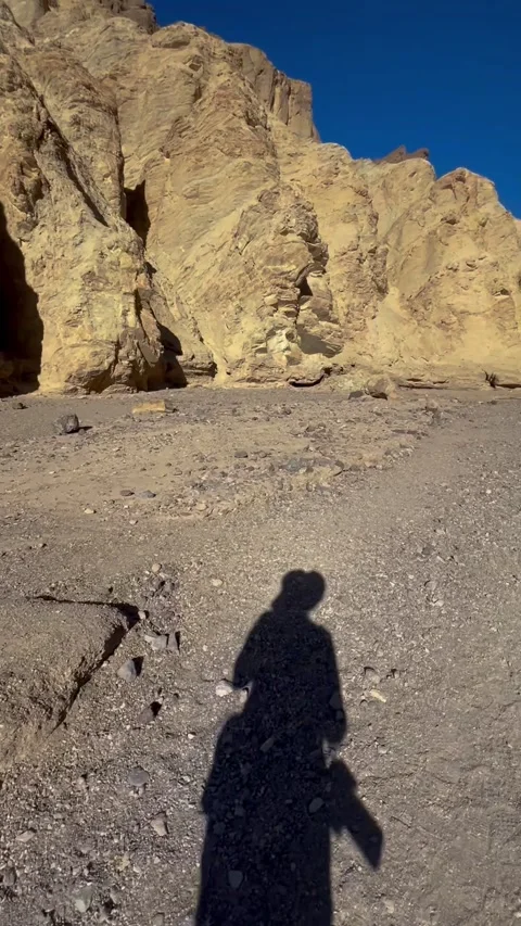 Videographer shadow walking and filming in Golden Canyon Death Valley desert Vídeos de archivo 331613769