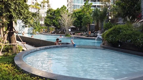  videographer shoots on camera with a stabilizer of a little boy in the pool. Vidéo 104701723