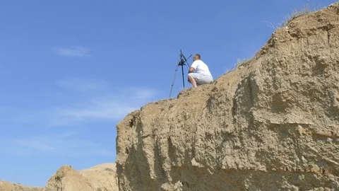 Videographer shoots the coast on a camera mounted on a tripod Stock-Footage 98997043