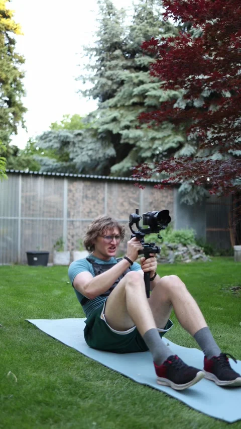 Videographer training core strength with camera gimbal Stock Footage 336370243