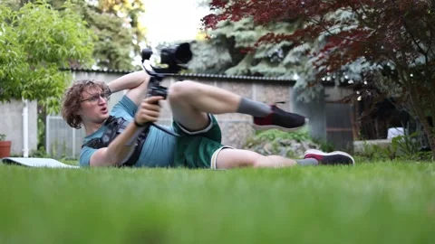 Videographer training with gimbal on grass Stock Footage 336791459