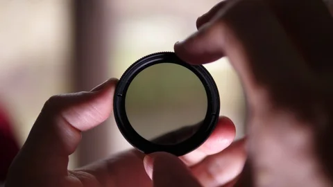 Videographer turning Neutral Density variable ND Filter and adding on Lens Stock Footage 119171508