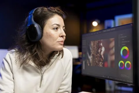 Videographer using editing software while listening podcasts Fotos de archivo