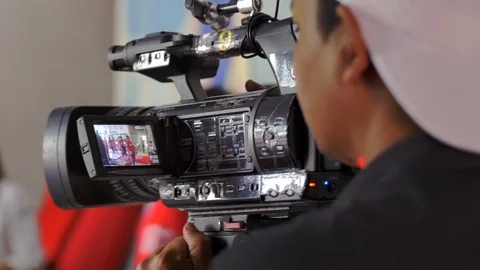 Videographer using a professional camcorder to record video at a live event Video stock 113134959