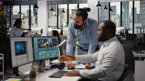 Videographers editing video footage on computer in creative agency Stock Photos